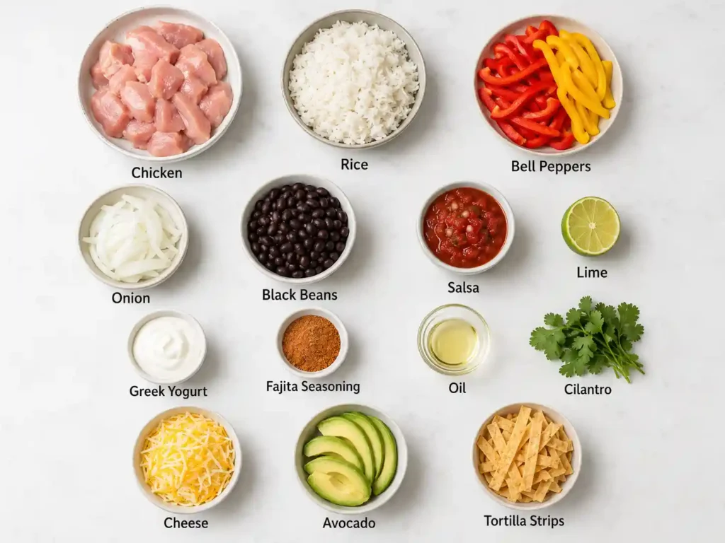 Labeled ingredients for chicken fajita rice bowls including chicken, rice, bell peppers, onion, black beans, salsa, lime, Greek yogurt, fajita seasoning, oil, cilantro, cheese, avocado, and tortilla strips.