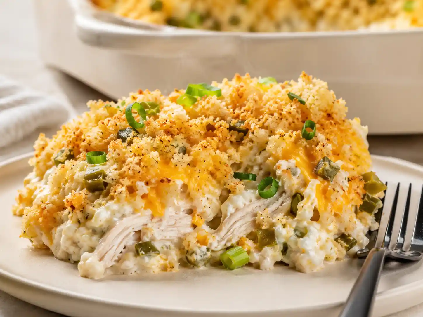 Close-up of creamy chicken, jalapeños, cheddar, and crisp panko inside jalapeño popper chicken casserole