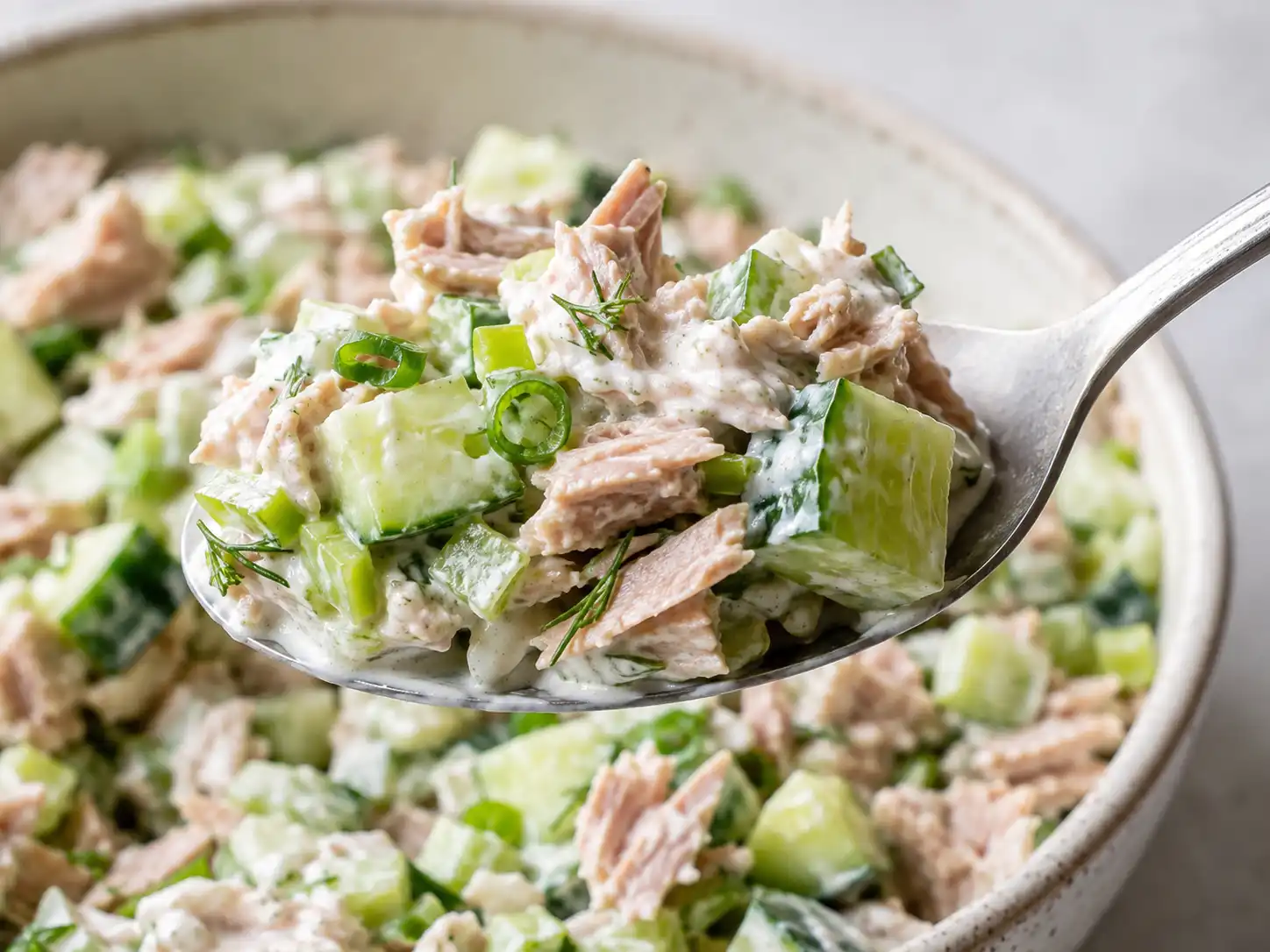 Close-up of creamy tuna salad with crisp diced cucumber